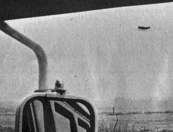 A Heflin frame shot through the passenger window of his Road Department van, the vehicle's side mirror in the foreground and the disc beyond.