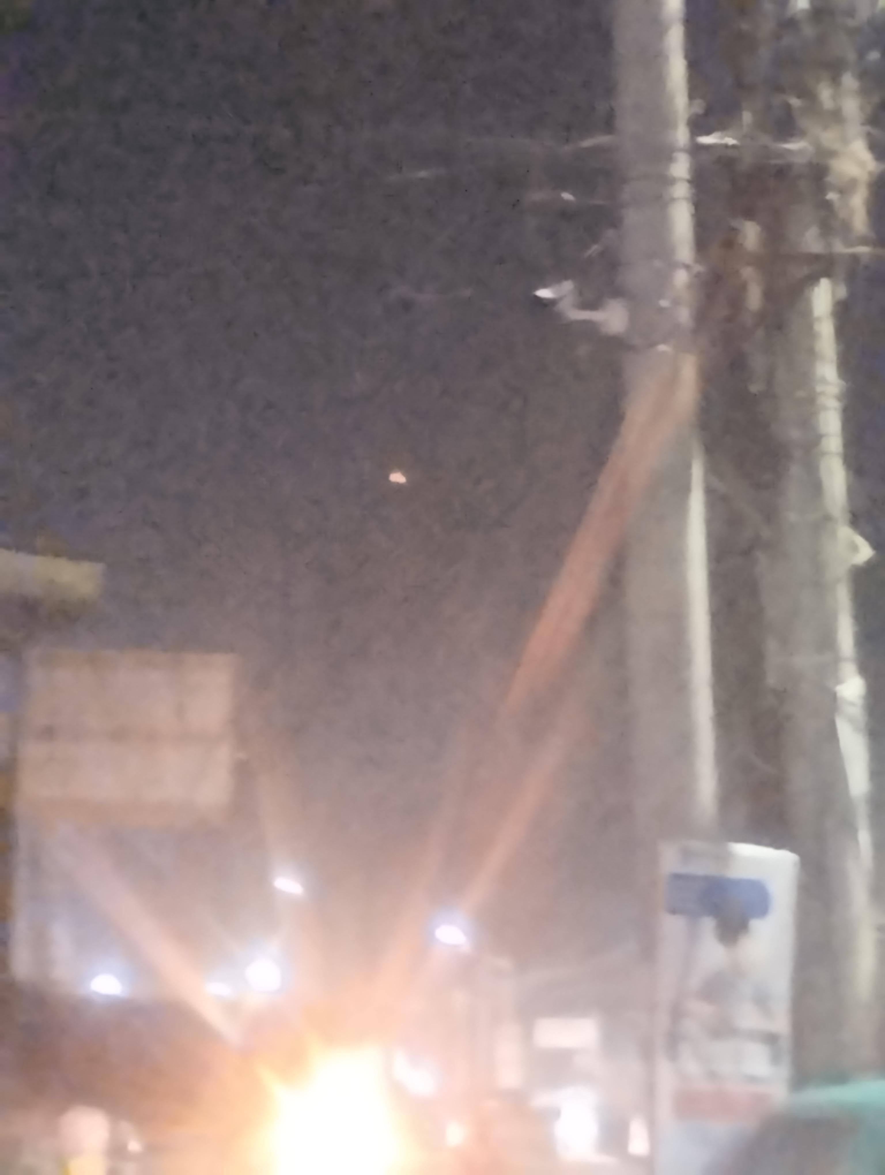 A second frame from the same sequence, the ground lighting and the object both rendered as soft discs by the out-of-focus lens. Witness photograph.