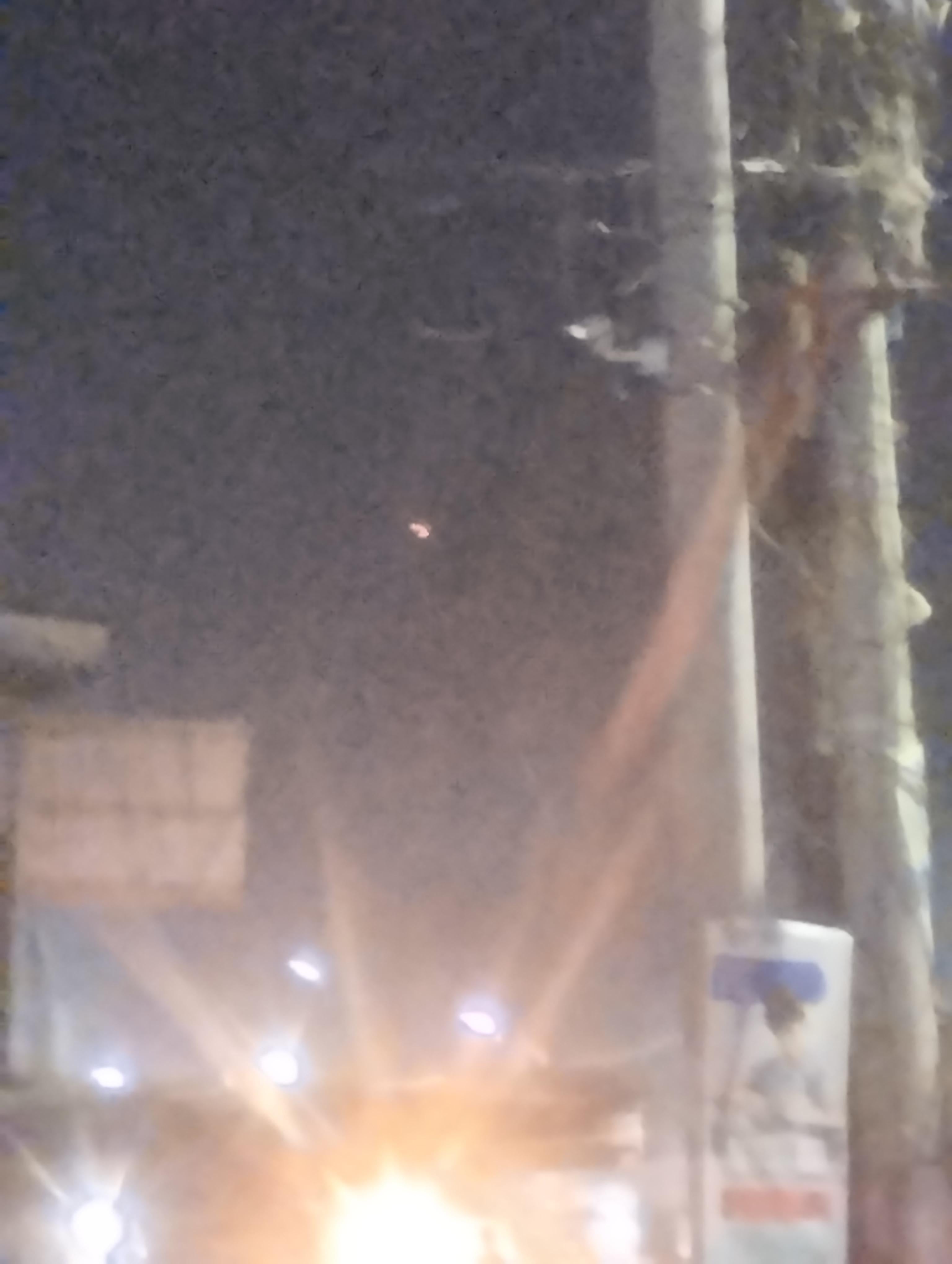 A third frame toward the airport, showing the spread of runway and street lighting below the object. Witness photograph.