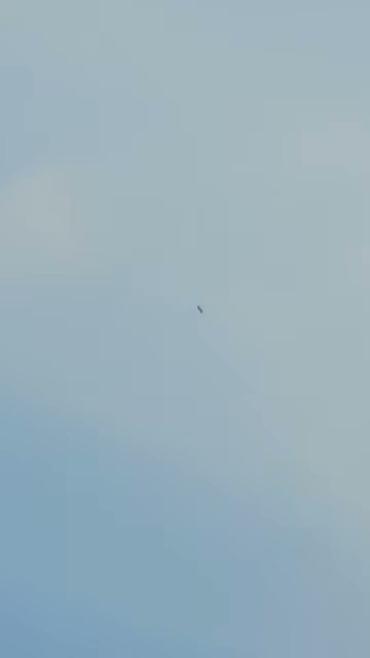 A later frame from the clip as the object drifts, with thin high cloud behind it.
