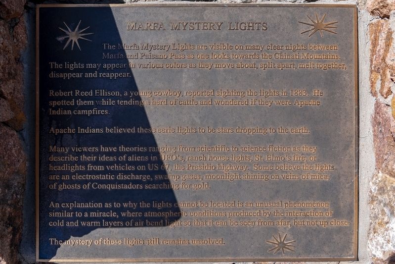 The second marker at the site, Marfa Mystery Lights. Read directly from this photograph, its inscription lists among the public theories "headlights from vehicles on US 67, the Presidio highway," and describes a mechanism "where atmospheric conditions produced by the interaction of cold and warm layers of air bend light so that it can be seen from afar, but not up close." Both components of the mainstream explanation are therefore named on the State of Texas signage at the viewing area itself. Photograph by Mansfieldphoto.com, 11 June 2025, via hmdb.org.