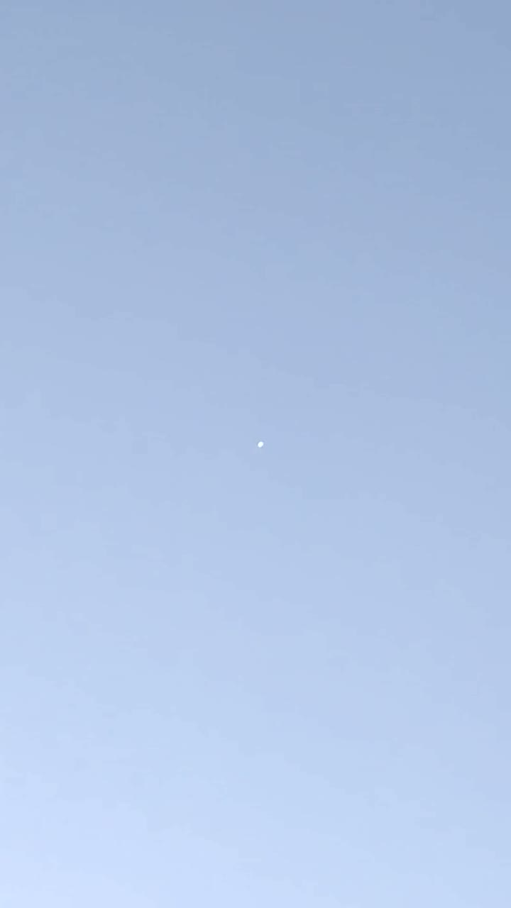 A brightened frame from early in the clip showing one of the bright round objects high in the twilight sky over Norfolk.