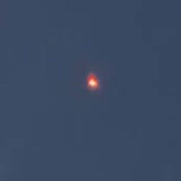 A brightened zoom on the amber point of light from early in the clip.